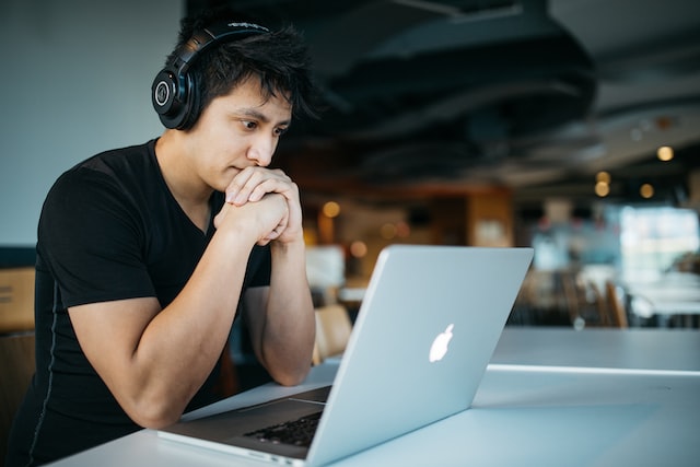 Adobe Experience Cloud image of man working on laptop, and wearing headphones