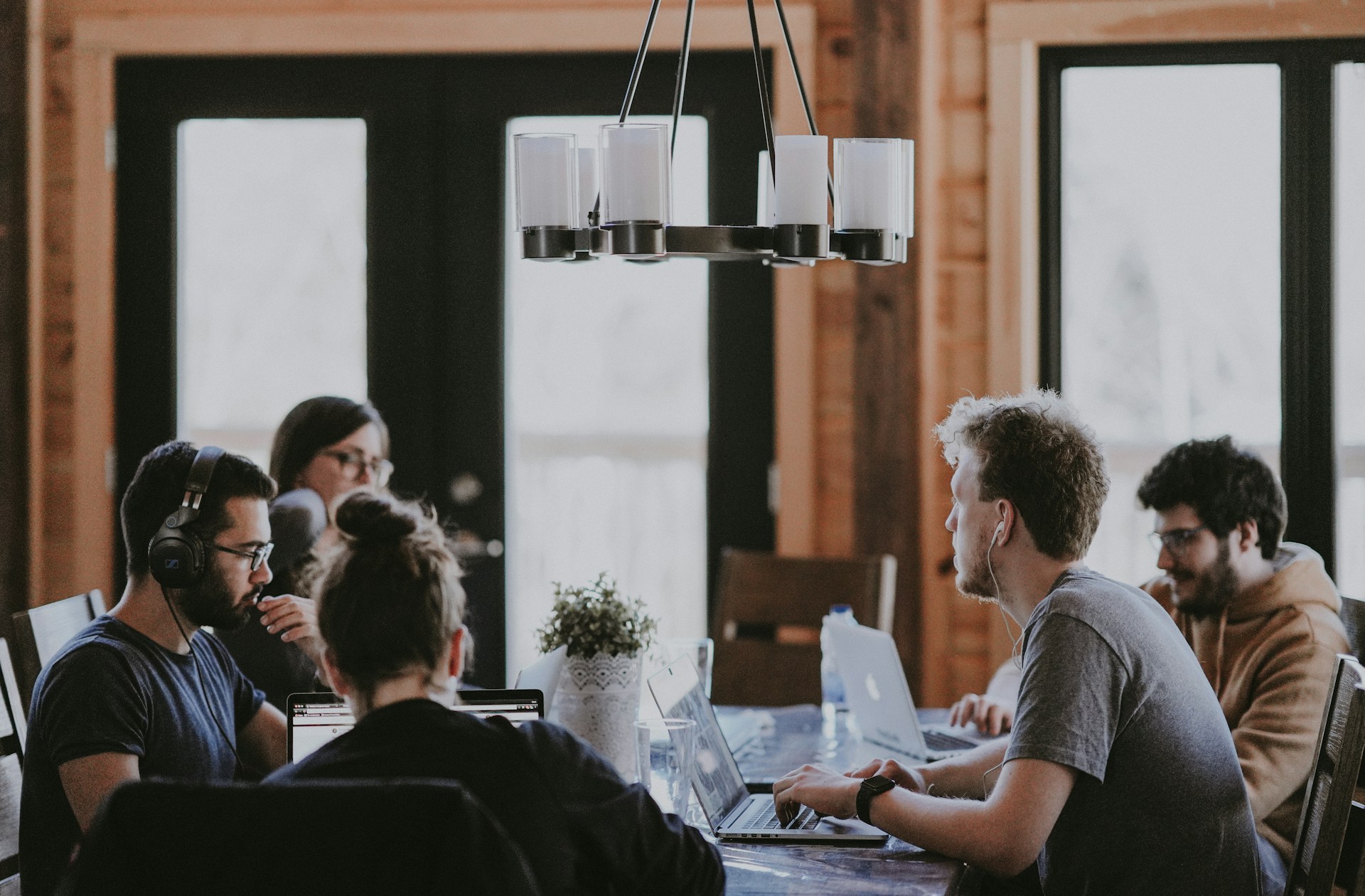 A group of young people working on laptops have a meeting